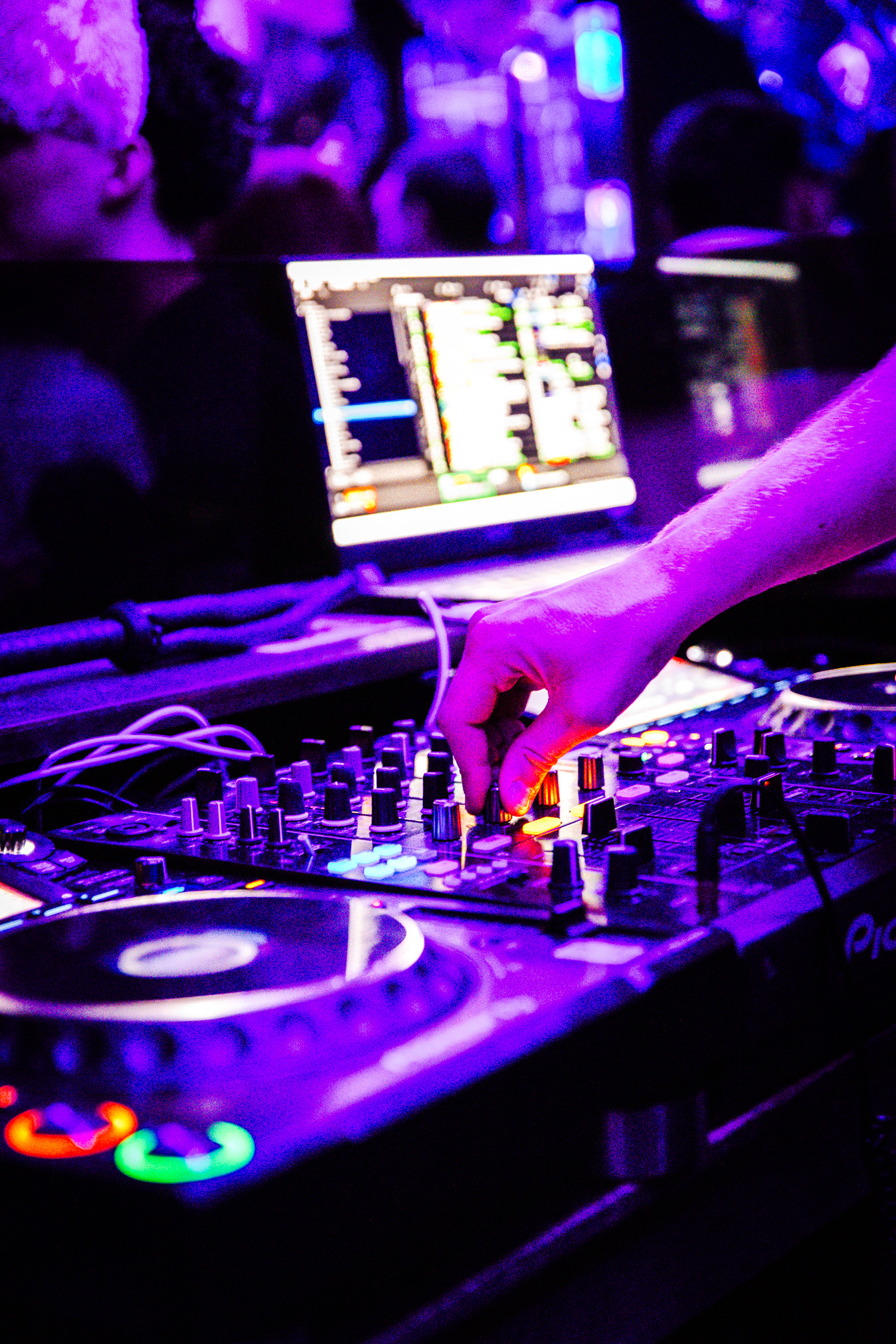 DJ set immersif sous des lumières néon violettes au cœur de la soirée.