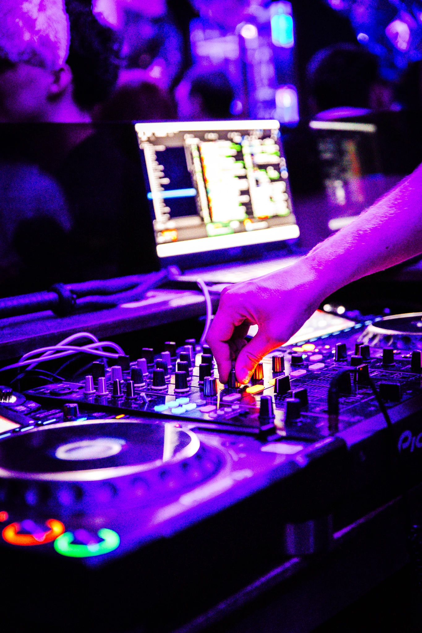 DJ set immersif sous des lumières néon violettes au cœur de la soirée.