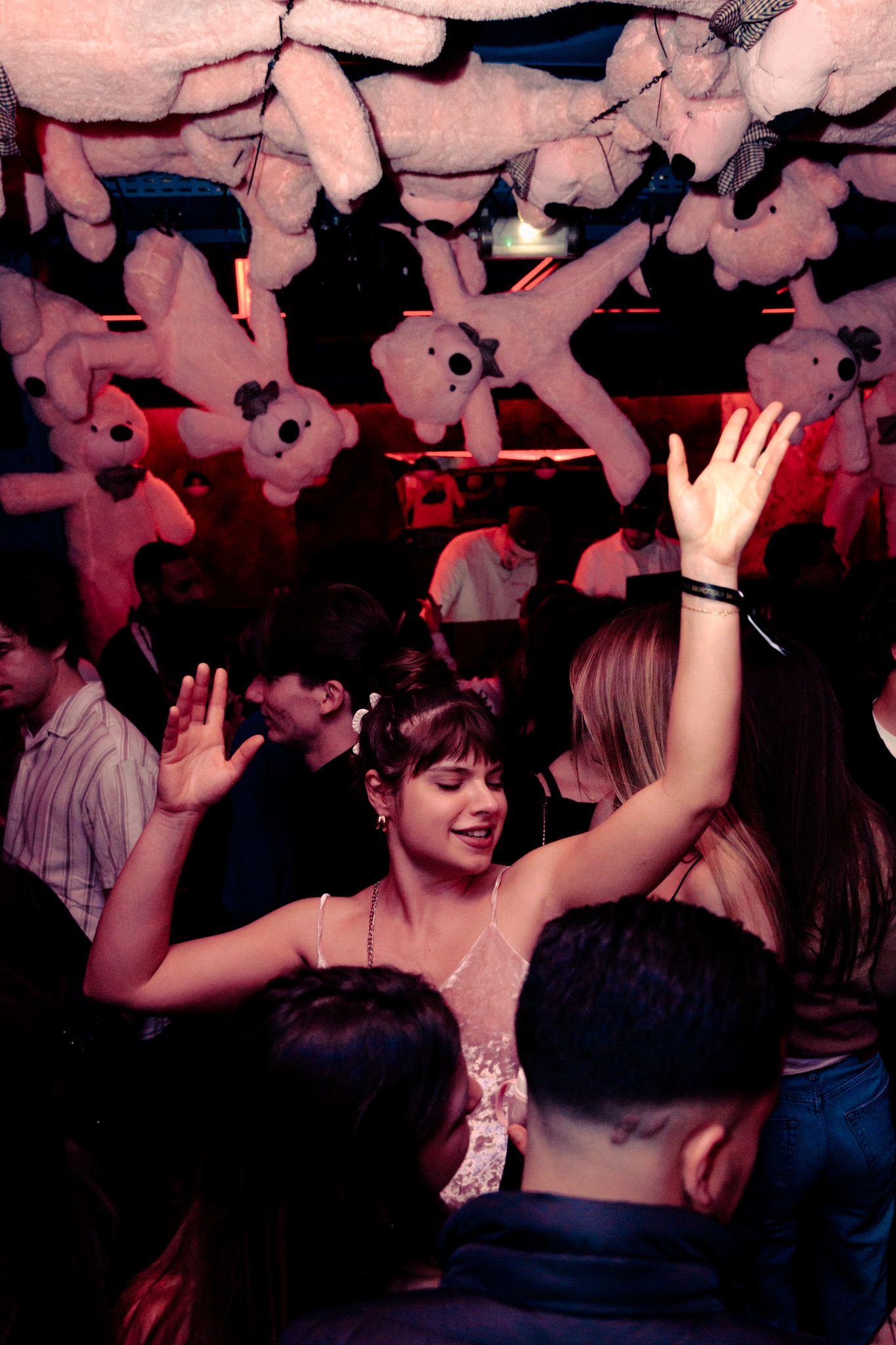 Les danseurs lèvent les bras au cœur d’une soirée immersive envahie d’ours en peluche roses.